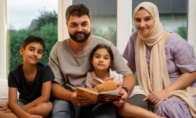a happy family of four enjoying a children's book